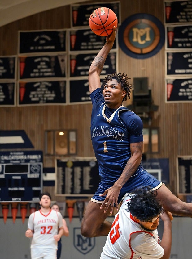 Central Catholic's Malakai Miller jumps over defender on his way to the hoop. He was whistled for an offensive foul, however. (Photo: Greg Jungferman)